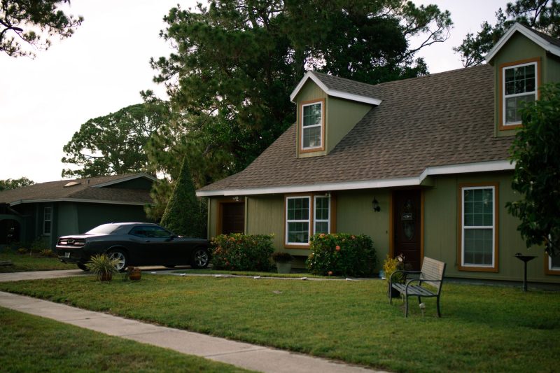Beautiful suburban home with a green lawn and a parked car, portraying residential comfort.